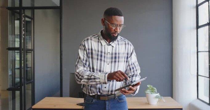 Businessman using tablet in modern office, analyzing data and staying focused