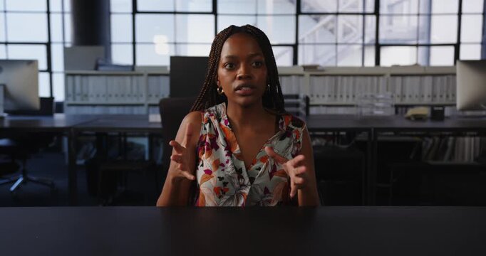 Businesswoman explaining strategy in modern office, using hand gestures for emphasis