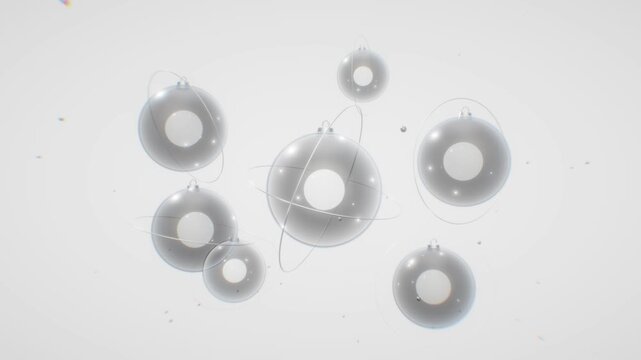 Sleek silver sphere ornaments with orbiting metallic rings hover gracefully over a high key white abstract background in 3D