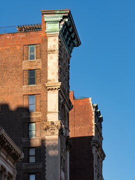 Ornate architectural detail of a historic brick building in New York City, SoHo, Manhattan, featuring a decorative entablature, copper cornice and classical facade ornamentation