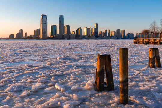 Frozen Hudson River with drifting ice floes with Jersey City skyline, New Jersey, during extreme winter cold weather. USA