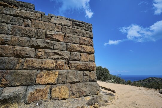 Ancient ruined wall in an arid landscape with a view of the sea and a clear blue sky, Palaiokastro, Ancient fortress, 3rd and 4th century BC, above Mandraki, Nisyros, Dodecanese, Greek Islands, Greece