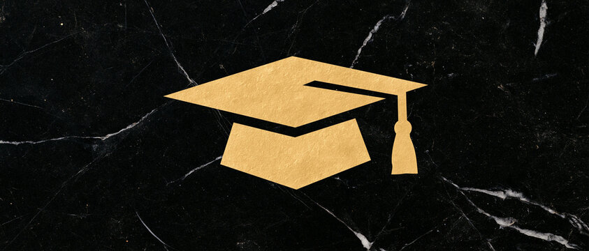 Golden graduation cap mortarboard placed on a dark black marble surface