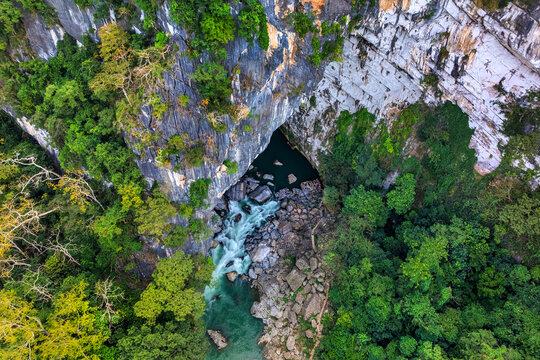 Aerial view of Tham Khoun Xe, the Xe Bang Fai Cave in Hin Nam No National Park, Boualapha District, Khammouane Province, Laos, surrounded by dramatic limestone karst and tropical forest.