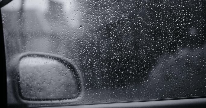 Cinematic black and white footage highlighting heavy rain and detailed raindrops. This moody monochrome video features wet surfaces and dark atmosphere, good for dramatic or melancholic concepts.