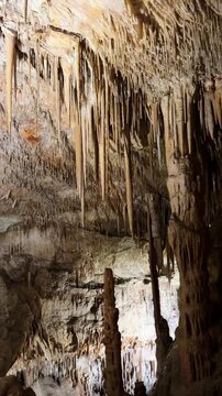 Explore nature view inside dark cave. Tourist attraction: caves stalactites and stalagmites rock formations hanging like dragon teeth. town Porto Cristo Mallorca Spain. vertical video Cuevas del Drach