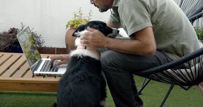 Man with Dog Using Laptop on Patio