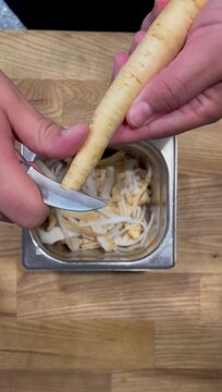 High-quality vertical stock video of peeling root vegetables with a paring knife, ideal for cooking recipe blogs, healthy eating social media reels, culinary masterclass trailers, and organic food.