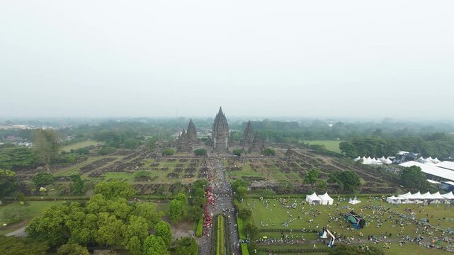 Aerial FPV forward flyover of the majestic Prambanan Temple complex during a crowded festival event, Indonesia