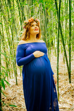 Pregnant white woman in blue dress with floral crown