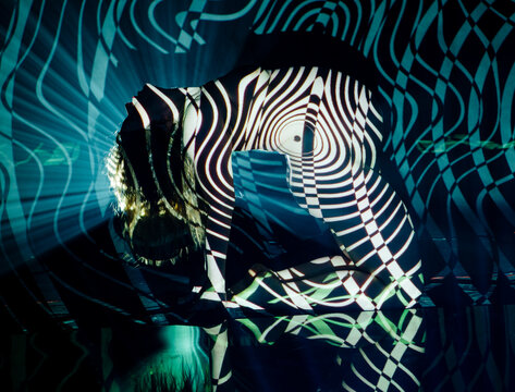 White woman posing with abstract striped projection