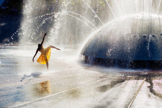 South Asian dancer performing in water fountain spray outdoors