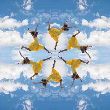 South Asian dancer in yellow dress jumping in sky kaleidoscope mandala