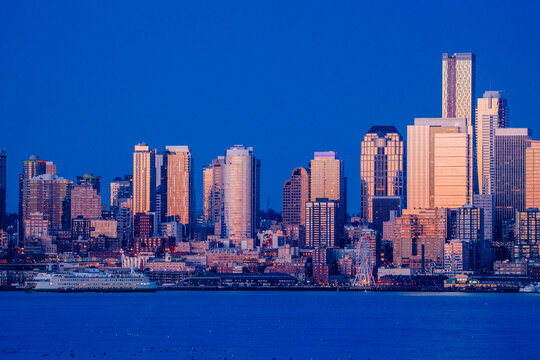 Seattle city skyline with ferry and waterfront at dusk