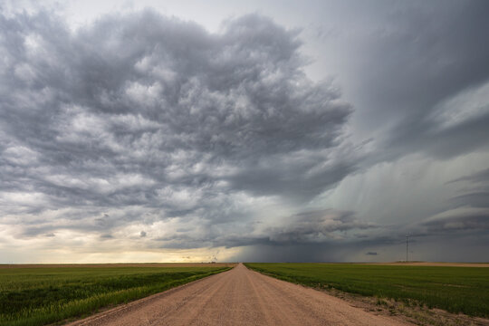 Farm Road under Developing Supercell thunderstorm in wyoming plains