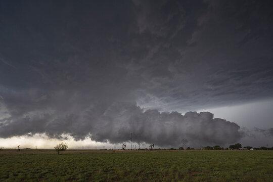 Storm cloud over grassy field with oil pumps in levelland texas