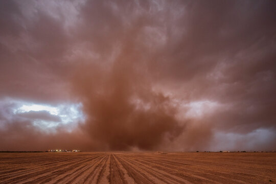 Supercell storm with dust cloud over open field