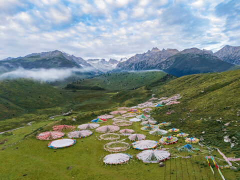 Tibetan buddhist Prayer Flag Circles in grassy valley with mountains