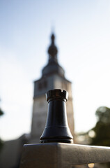 Chess rook in the foreground with a blurred historic tower in the background © Mark