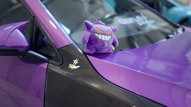 Gengar Pokemon plush toy on purple car windshield