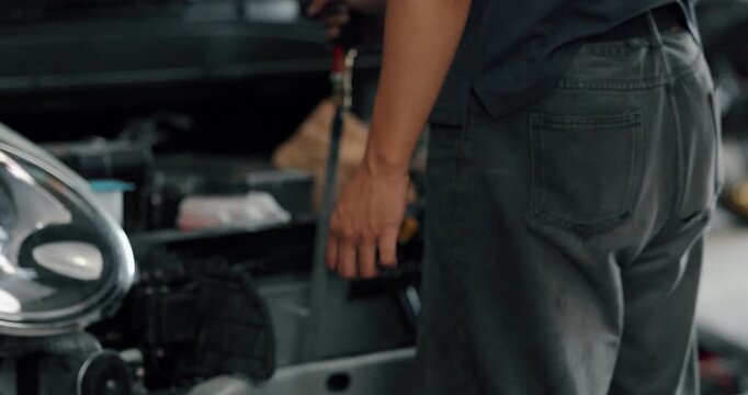 Mechanic cleaning EV radiator and condenser by spraying water and blowing air dry in service garage