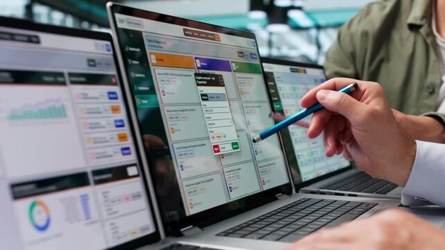 Two Men Discussing ERP Software Solutions On Laptops