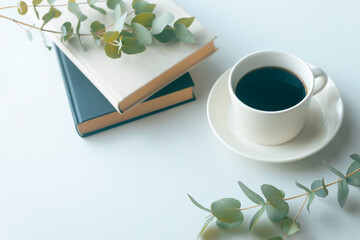 Coffee cup with books and eucalyptus on white background with copy space © 清美 小池