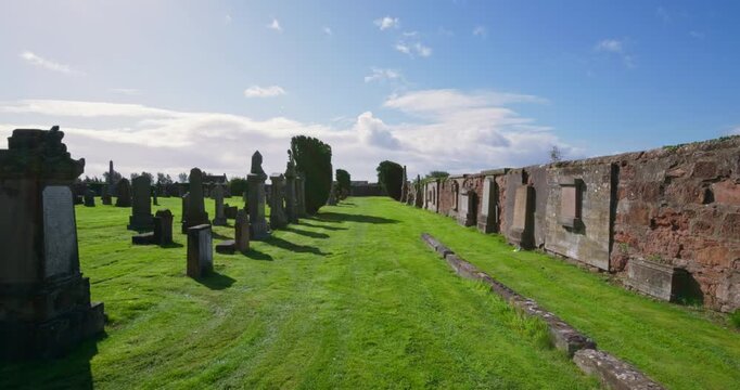 Gimbal walking through old graves in Scottish coastal town's cemetery 4