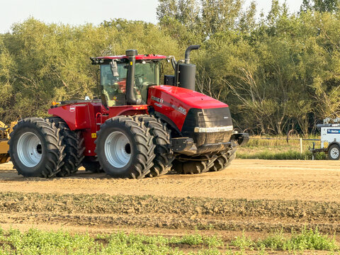 Saskachewan, Canada - August 20, 2026: Case IH Steiger 696 articulated four-wheel drive tractor with dual wheels working farmland on Saskatchewan prairie