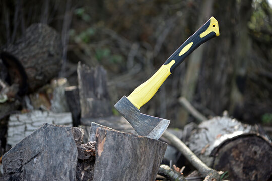 an axe in a stump. axe embedded in a wooden log, evoking notions of forestry, craftsmanship, and outdoor activities in nature. preparing firewood for the winter. work in the village. active lifestyle