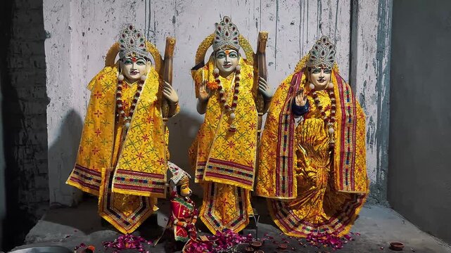 Lord Rama, Goddess Sita, and Lakshman together in traditional ceremonial clothing, beautifully decorated with golden ornaments, floral garlands, and intricate crowns.