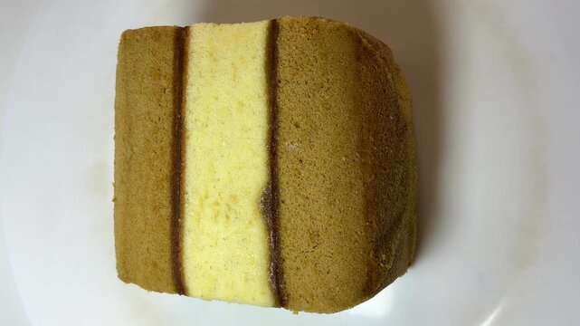 Top view video of Lapis Surabaya, Indonesian layer cake Spiku with jam filling on white plate.