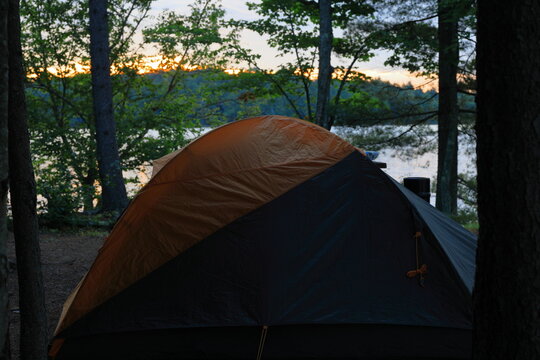 Backpacker makes camp at a primitive campside on a lake in the Adirondack wilderness