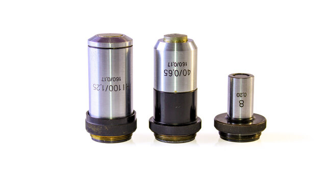 Set of three microscope objectives marked 100/1.25, 40/0.65 and 8/0.20, with 160/0.17 tube length markings, isolated on a white background.