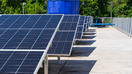 Low angle view of solar panels aligned in row near metal fence © Suprachai