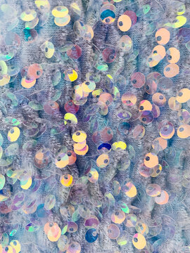 colorful pastel close up sequin on blue fabric texture background