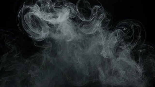 Wispy white smoke plumes rise and swirl in a dark studio environment with subtle lighting