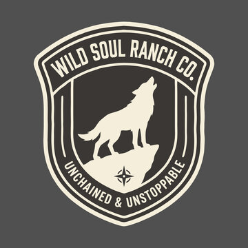 Vintage style logo design featuring a howling wolf on a mountain cliff inside a shield emblem with inspirational text