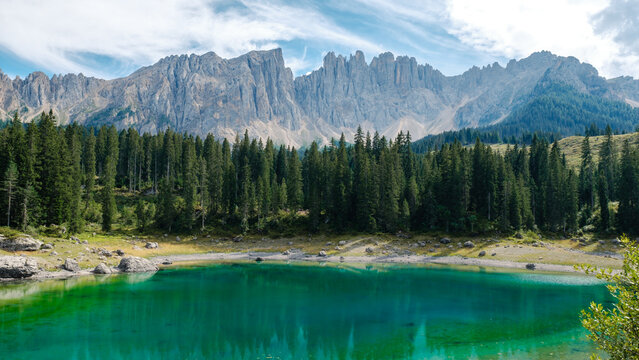 Nestled in the Dolomites of Italy, Lago di Carezza showcases a stunning emerald lake surrounded by lush forests and majestic peaks. This serene destination offers breathtaking views for visitors.