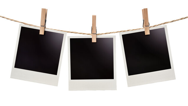 Three blank instant photo prints hanging on a twine line with wooden clothespins, isolated on transparent background