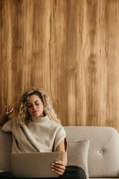 Woman relaxing at home working on laptop