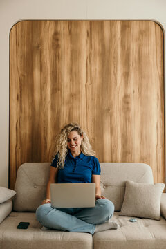 Woman working from home using laptop on couch