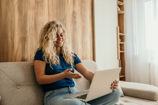 Happy woman making video call on laptop from home