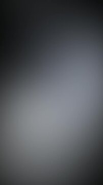 Vertical 9:16 soft glowing chrome silver lights drifting on dark background, seamless abstract gradient loop for automotive, technology and product titles