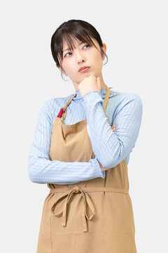 考えごとをするエプロン姿の女性, Woman Thinking While Wearing an Apron