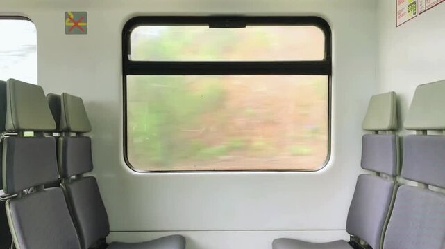 Interior train journey viewed from inside a moving passenger train, looking through the window at passing railway tracks and scenic countryside landscape, travel transportation footage