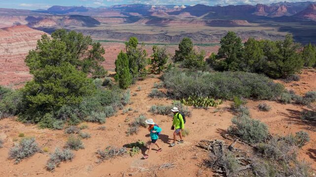 Aerial view of mature couple exploring Gooseberry Mesa, enjoying stunning views of Zion National Park while hiking on the trails