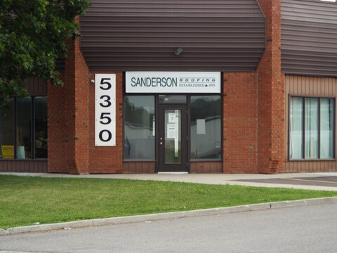 Ottawa, Ontario, Canada &ndash; July 19, 2026: "Sanderson Roofing storefront" at building 5350 features a brick exterior, large glass windows, and a grassy area in front on Canotek Rd.
