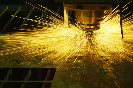 Splashing sparks from a fiber laser cutting machine during a metal plate cutting process