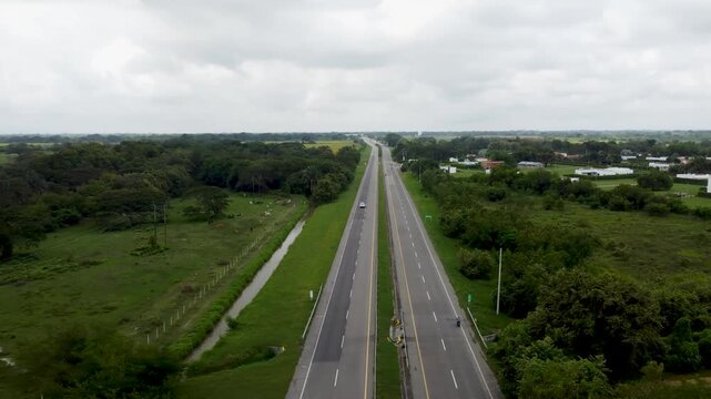Aerial view drone of empty road clouddy day grass and forest area, Tolima, Colombia 4k